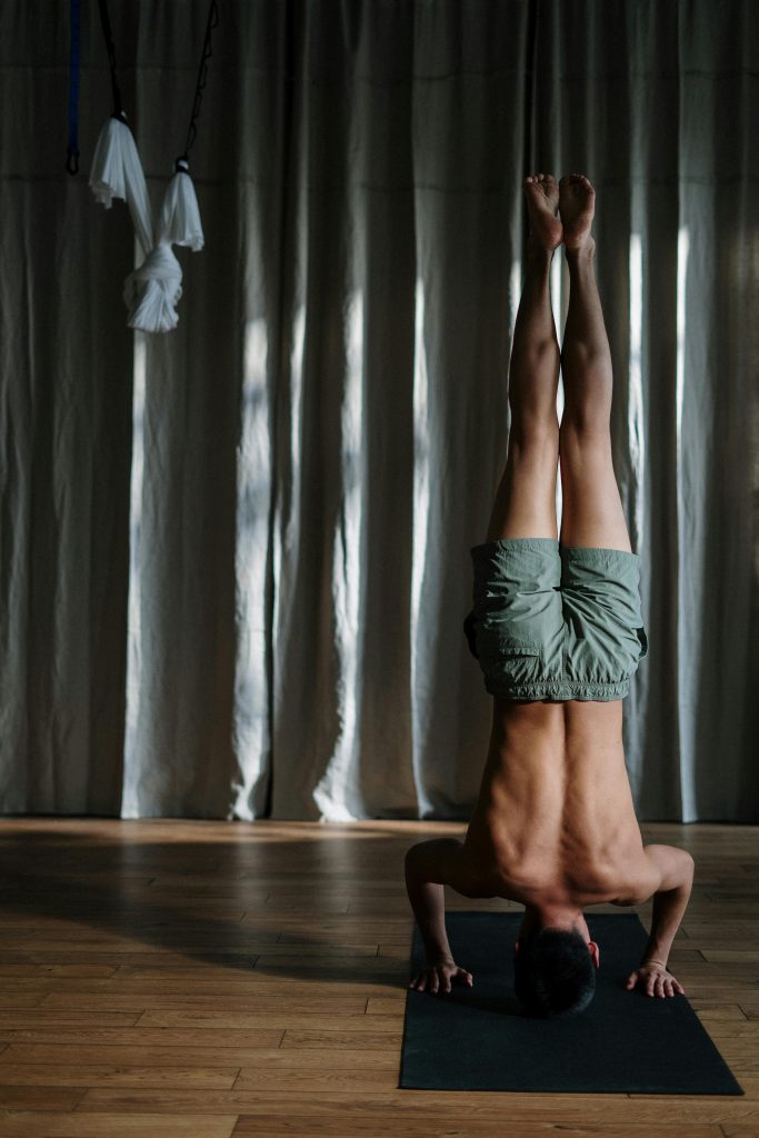 Homme faisant du yoga sur son tapis noir